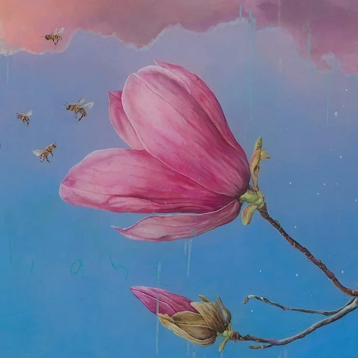 A pink flower with full bloom and a closed bud on a branch, against a sky-blue background with bees flying nearby.