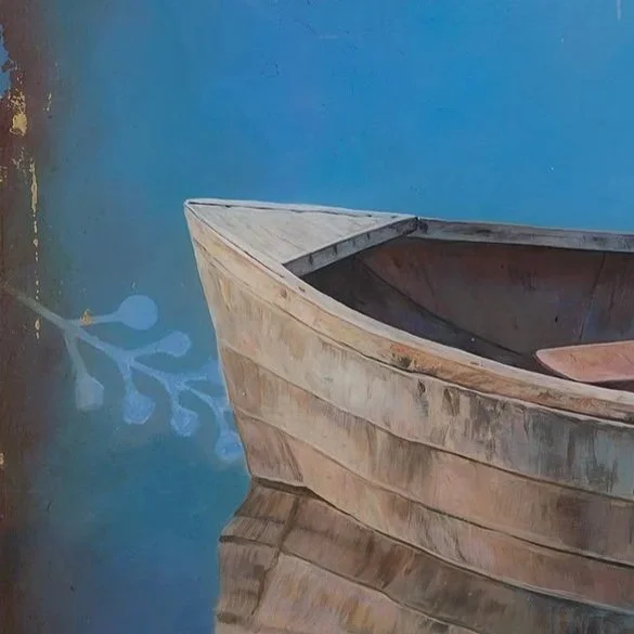 Close-up of a wooden boat floating on calm water with a blue background
