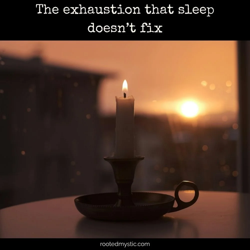 Old fashioned candle holder with lit candle against window & sunset
