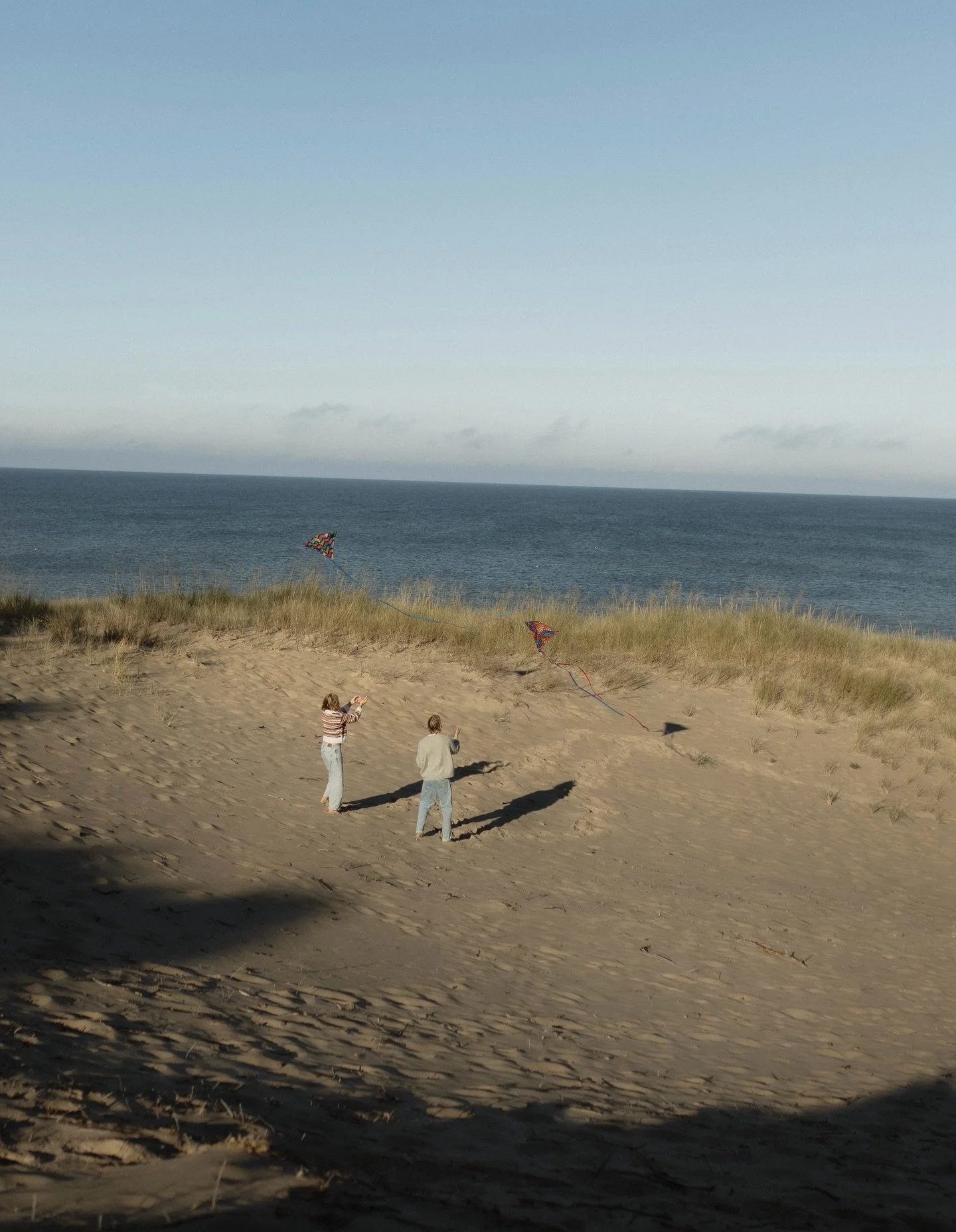 A kite date on the beach in Michigan. A mix of digital and film edits. 

Engagement pics. Beach photoshoot. Sweaters on the beach. Kite date. Couple photoshoot. Couple photos. Couple outfits. Candid. Emotion. In love. Engagement photoshoot. Date idea