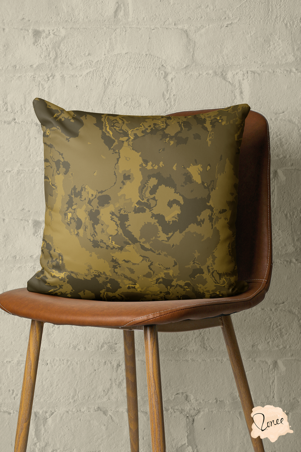 Dark golden brown moderm abstract throw pillow on a vintage wood and leather chair with a brick wall behind.