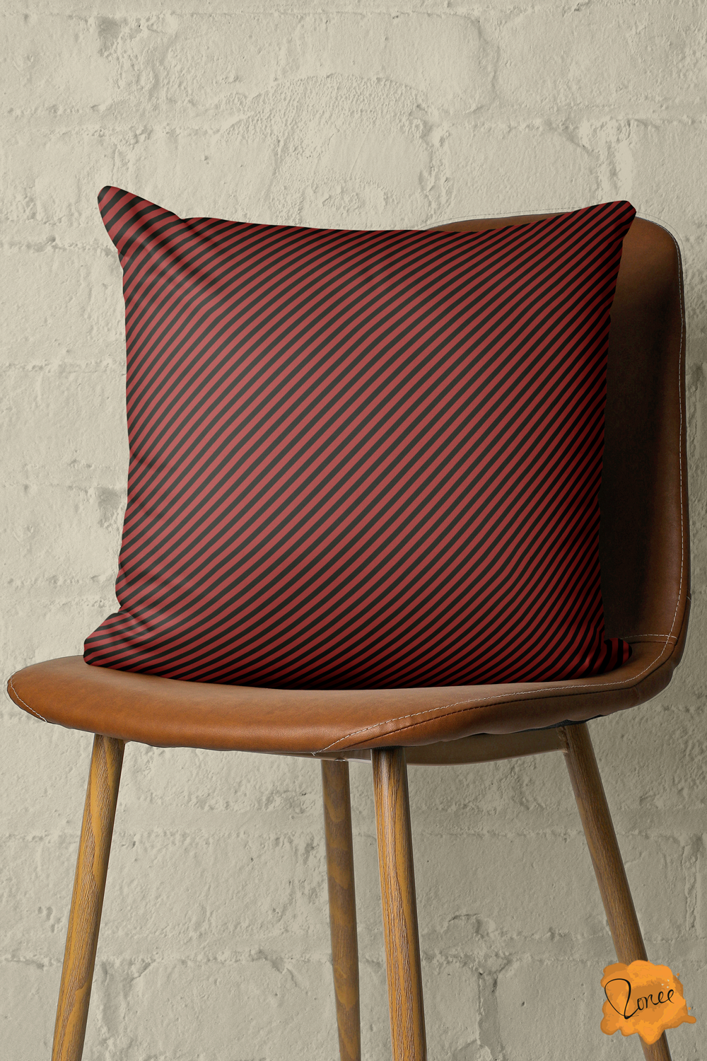 Black and dark cherry red striped throw pillow on a wood and leather chair in front of a painted brick wall.