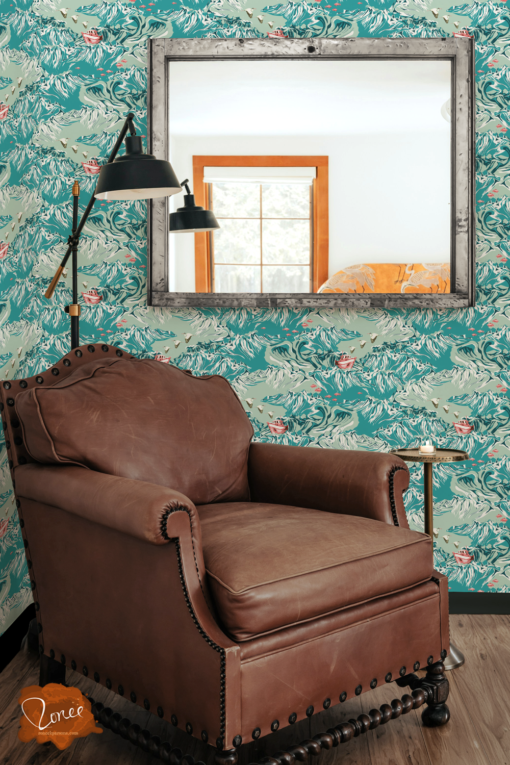 Old leather chair with a black floor lamp and vintage mirror in a room with nautical maximalist wallpaper in turquoise, with fish and a small fishing boat.