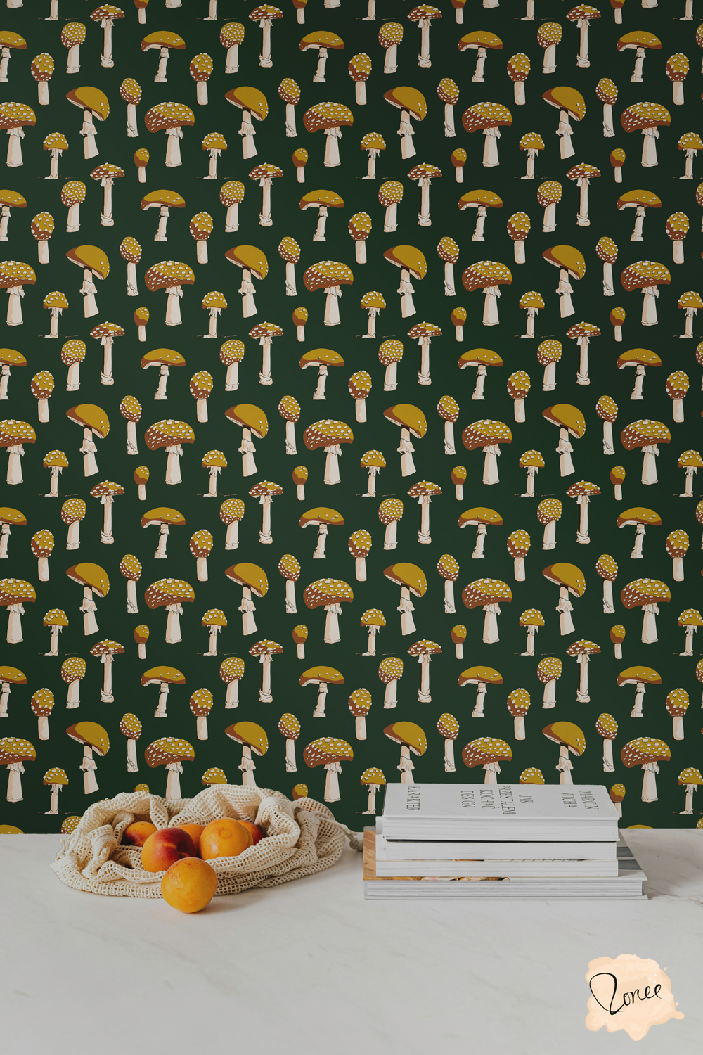 Funky yellow mushrooms on dark green wallpaper behind a white kitchen counter with a mesh bag spilling oranges and a stack of cookbooks.