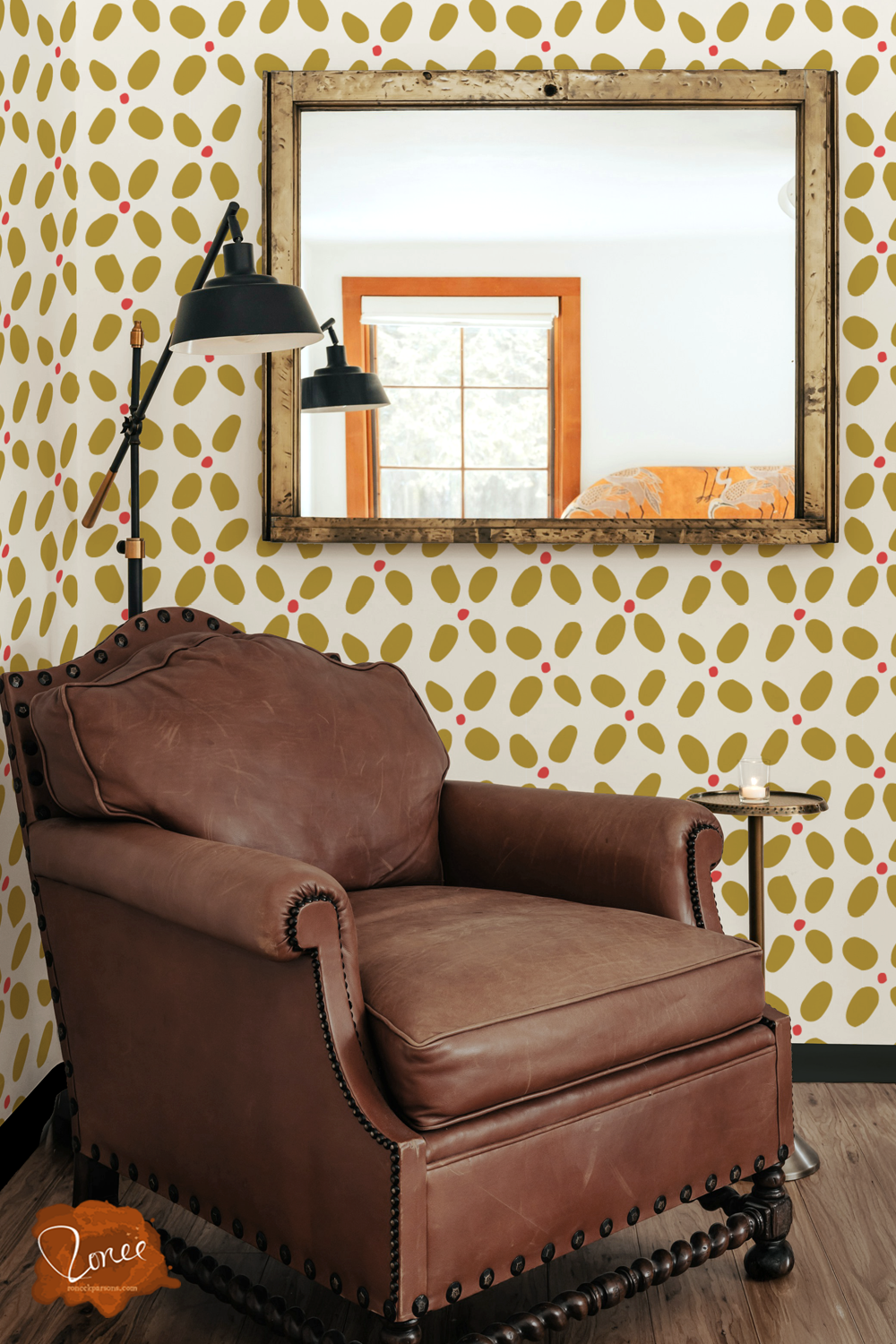 Old leather chair with a black floor lamp and vintage mirror in a room with maximalist big stitch geometric wallpaper in mustard and white.