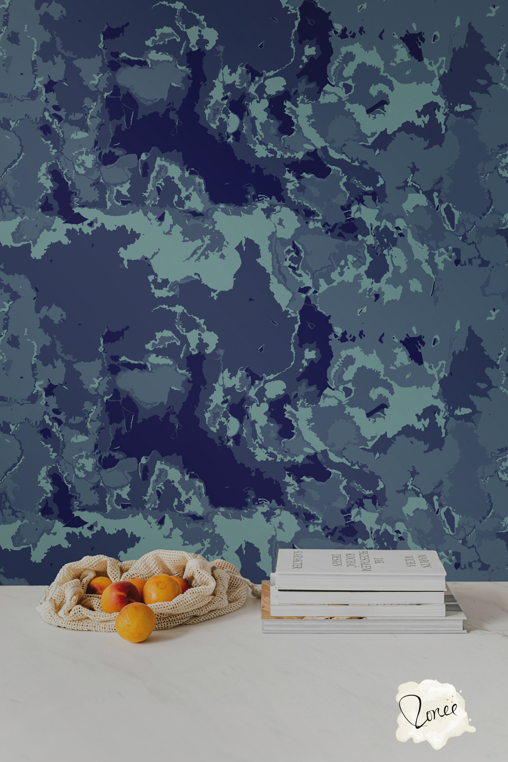 Moody dark sea blue marbled abstract wallpaper behind a white kitchen counter with a stack of cookbooks and a mesh bag spilling oranges.