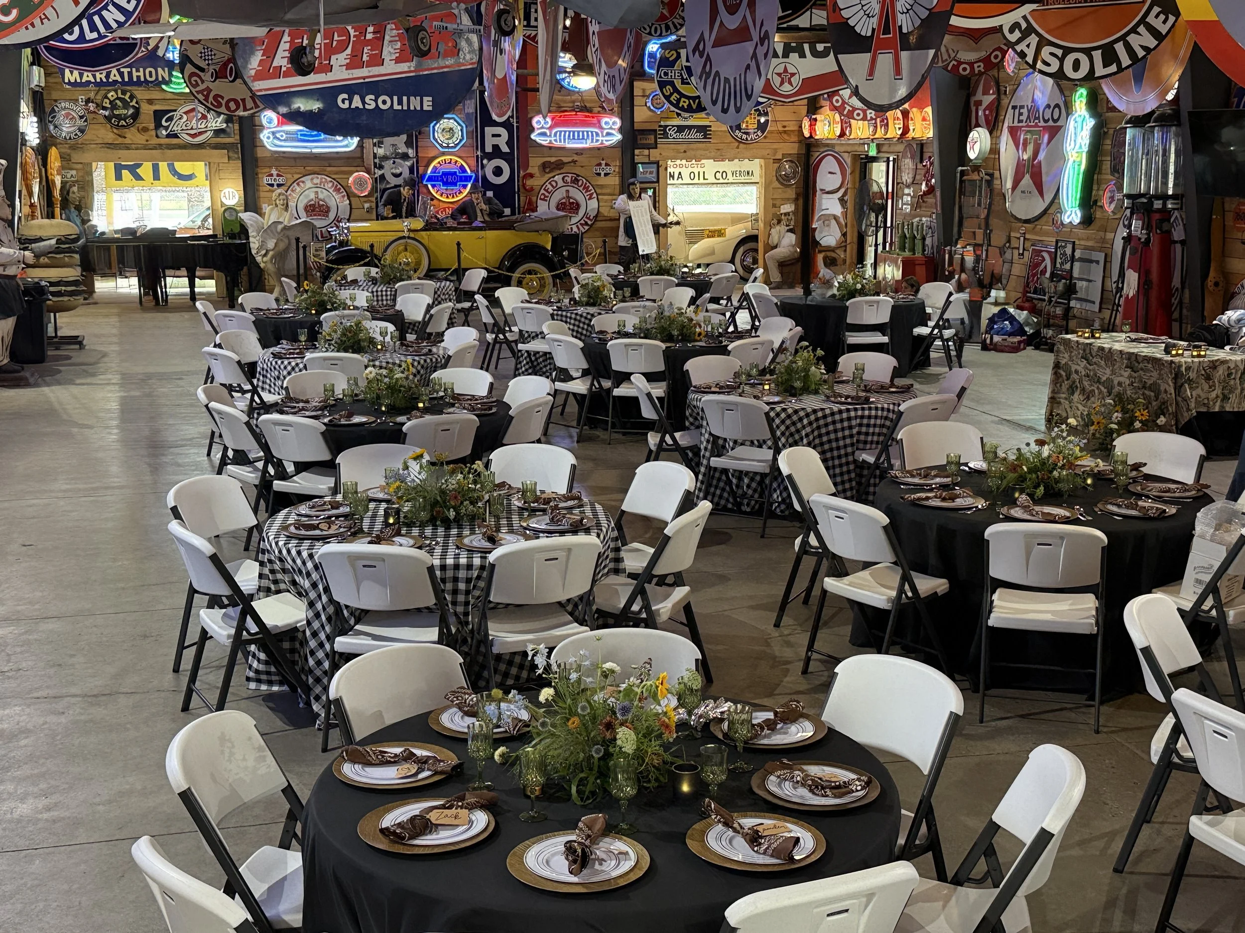 Rehearsal dinner venue in Provo with round tables set among antique gas pumps and vintage signs