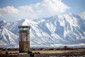 Control tower at Provo Airport with a dramatic backdrop of snow-covered Wasatch Mountains, illustrating the scenic beauty and convenience of flying out of Utah County.