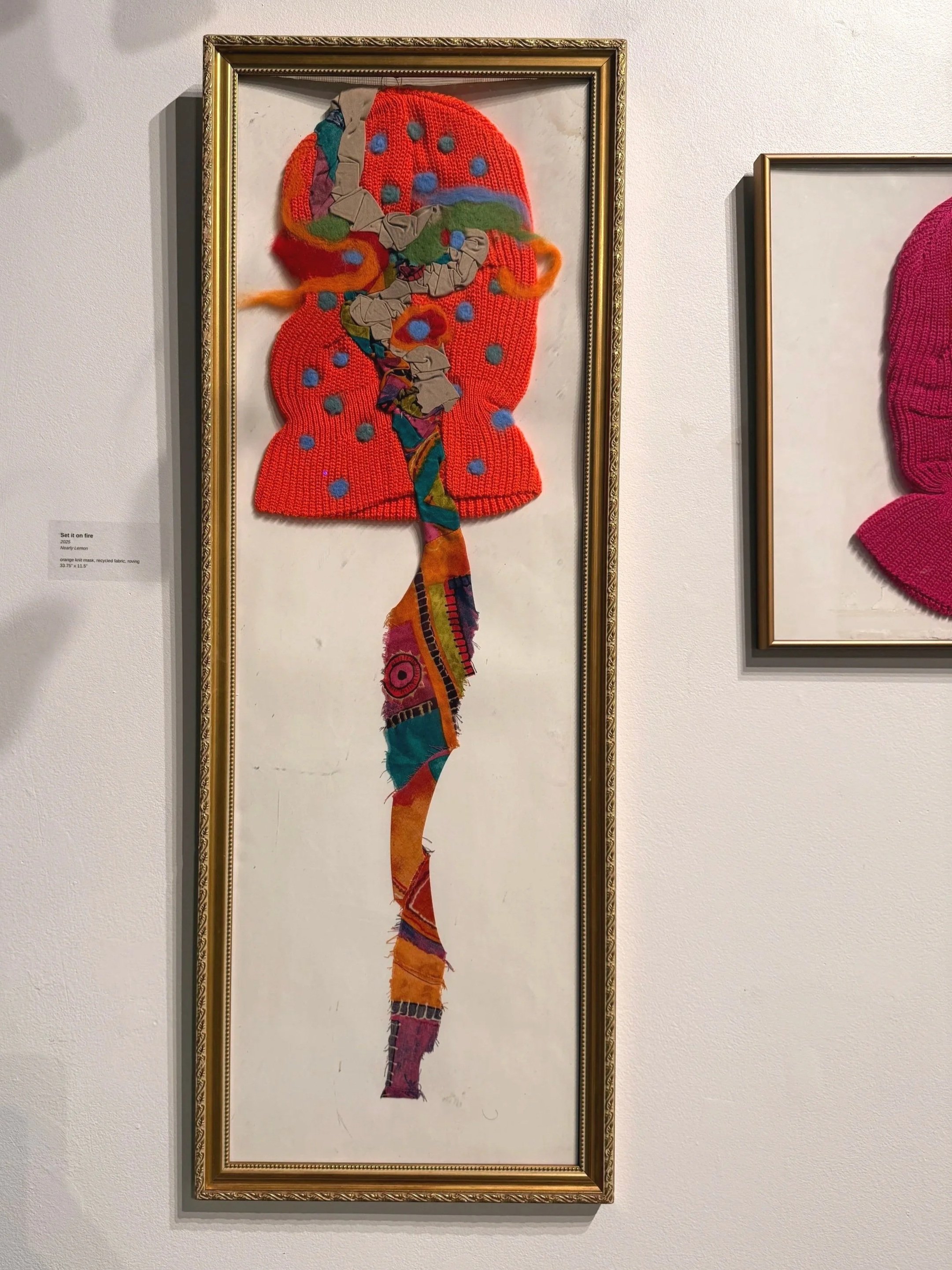 Installation Image I 
Set it on fire
2025
Nearly Lemon

orange knit mask, recycled fabric, thread, wool roving
33.75” x 11.5”