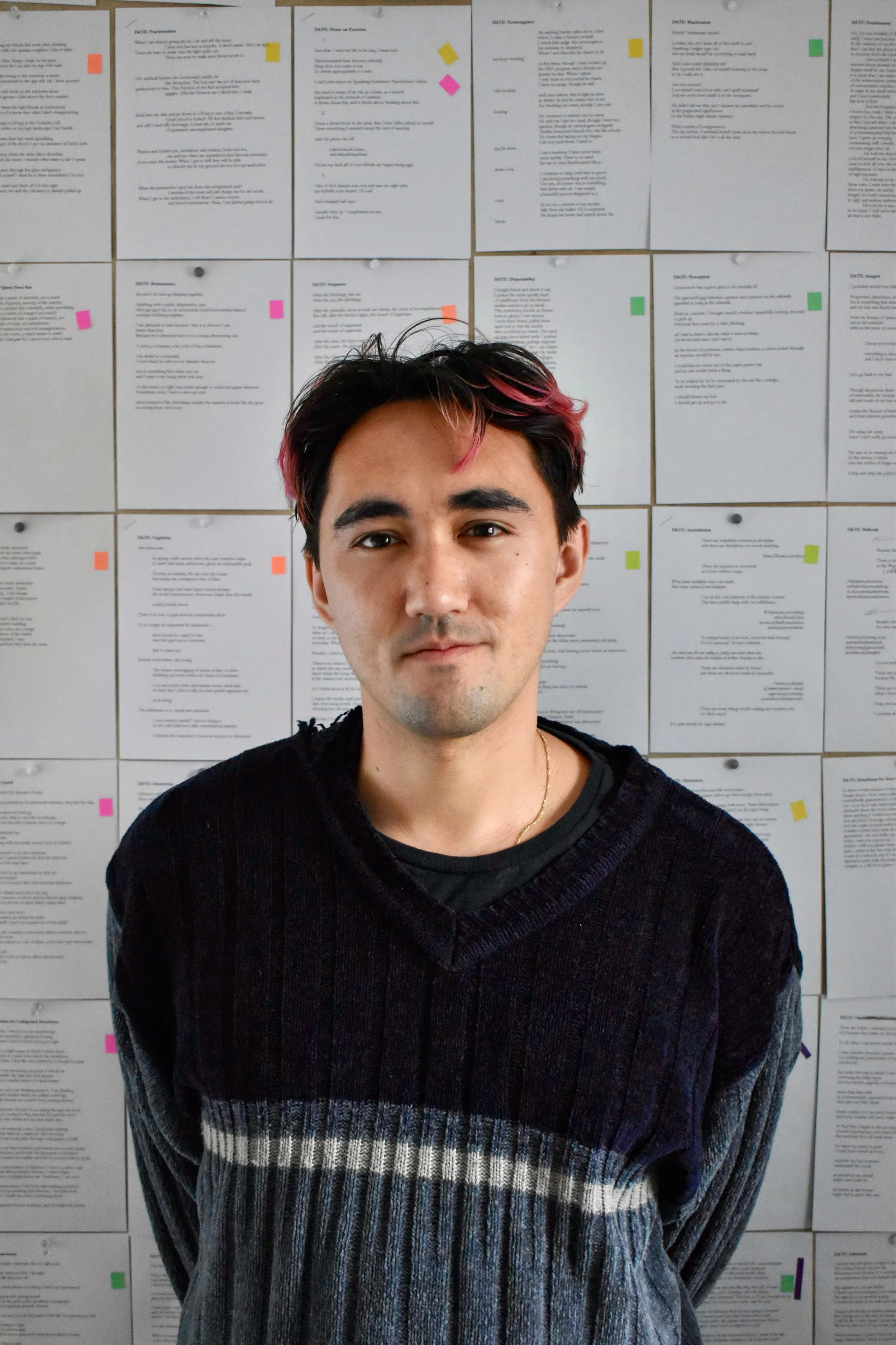 Rob in his favorite blue sweater in front of a wall covered in poems.