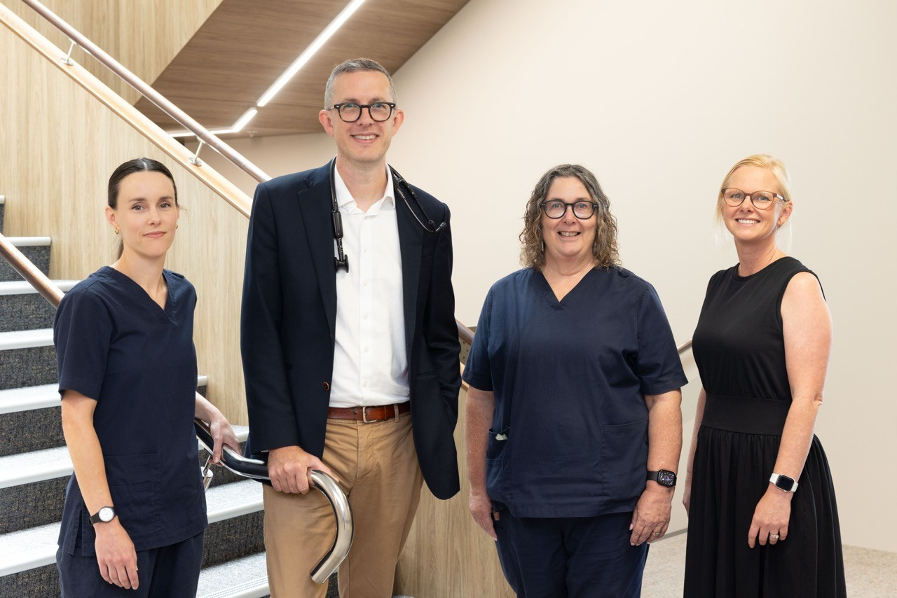Hawke's Bay Respiratory and Sleep medical professionals standing on a staircase in a medical facility, smiling at the camera.