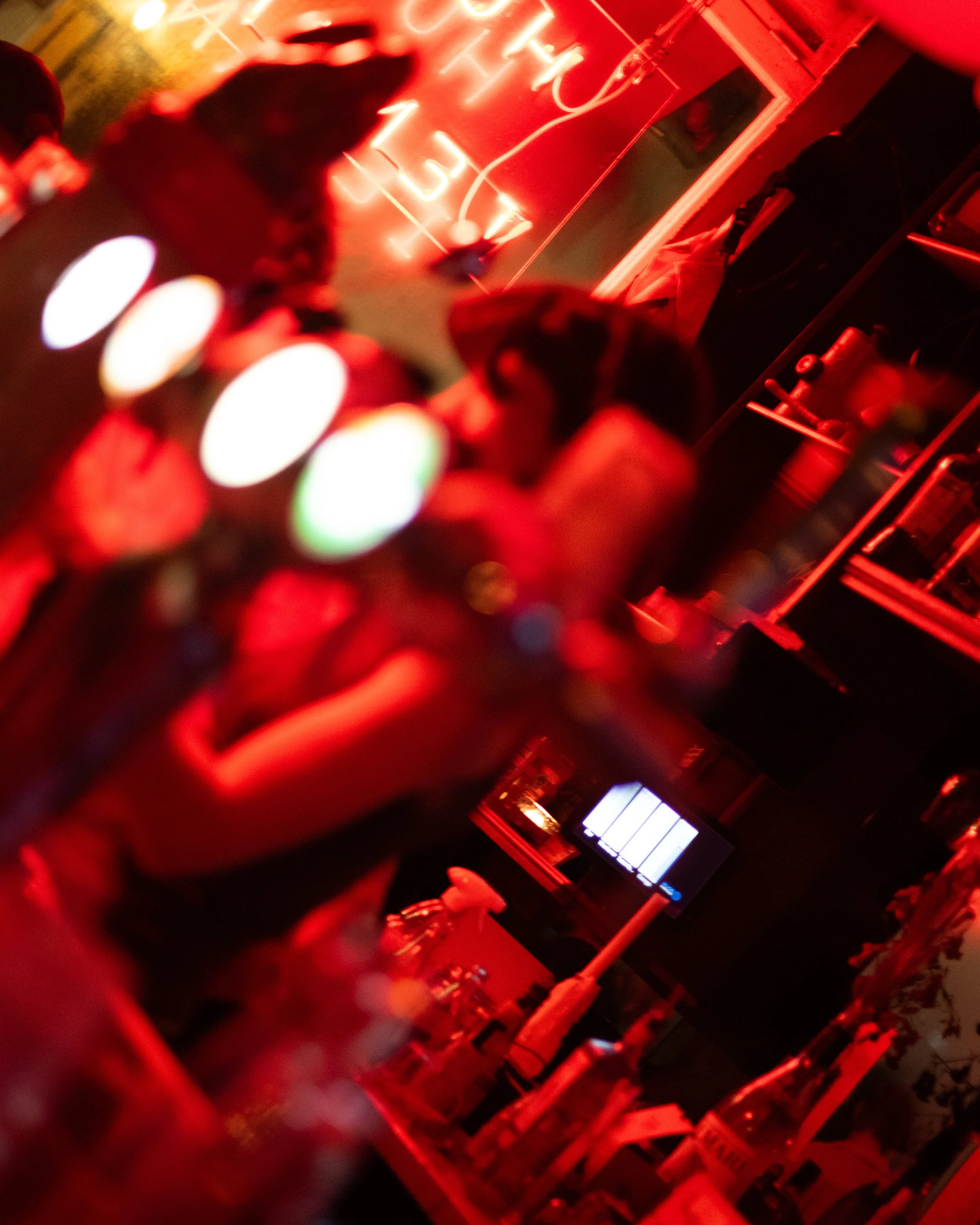 Bar scene with bottles and neon lights, red ambiance