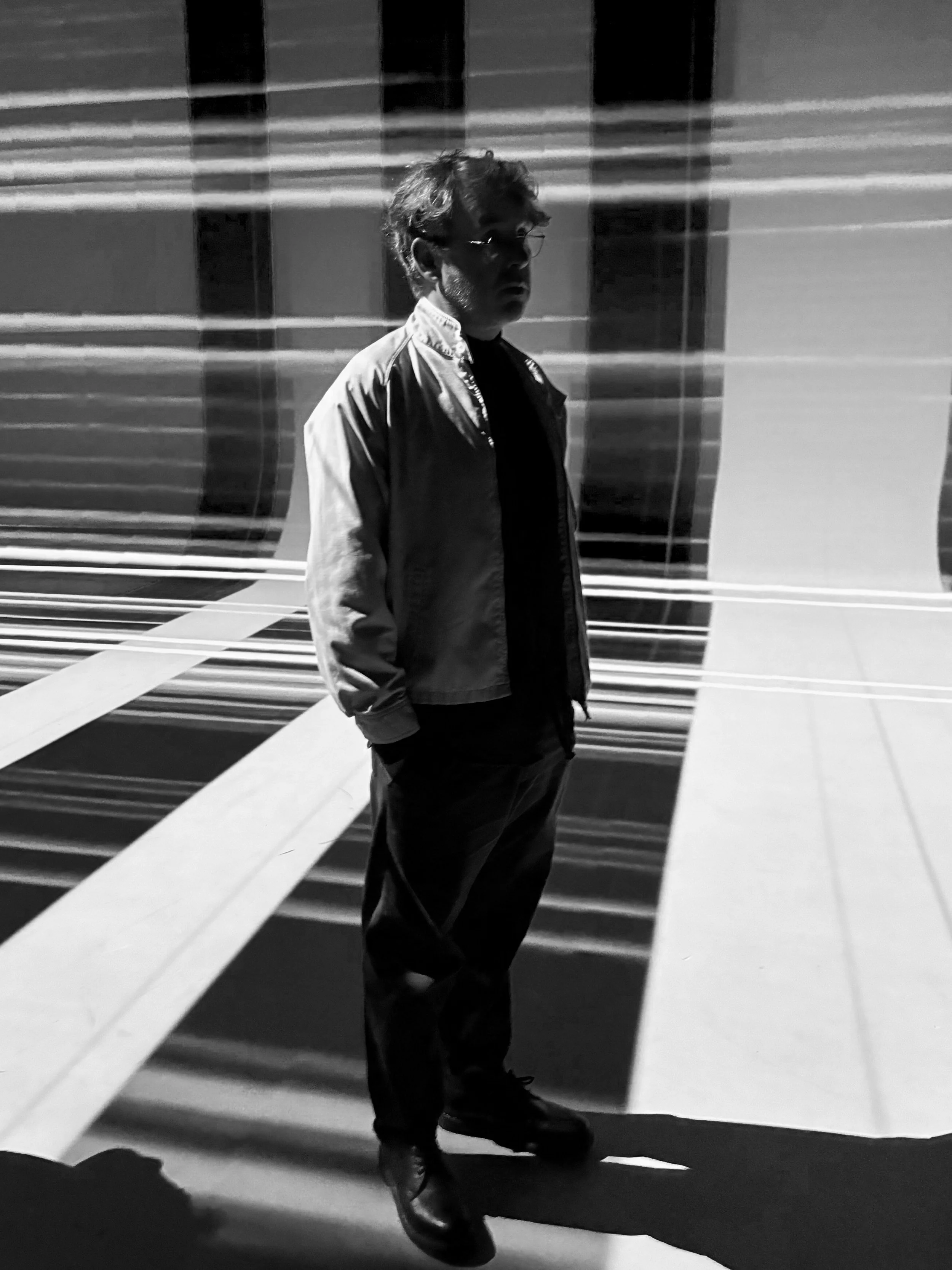 Person in a striped light installation, black and white photo
