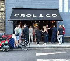 Logo featuring a large black oval and the words 'UNIQUE BEAUTY' with stylized letters 'U' and 'B' and small blue eyes inside the 'B'.