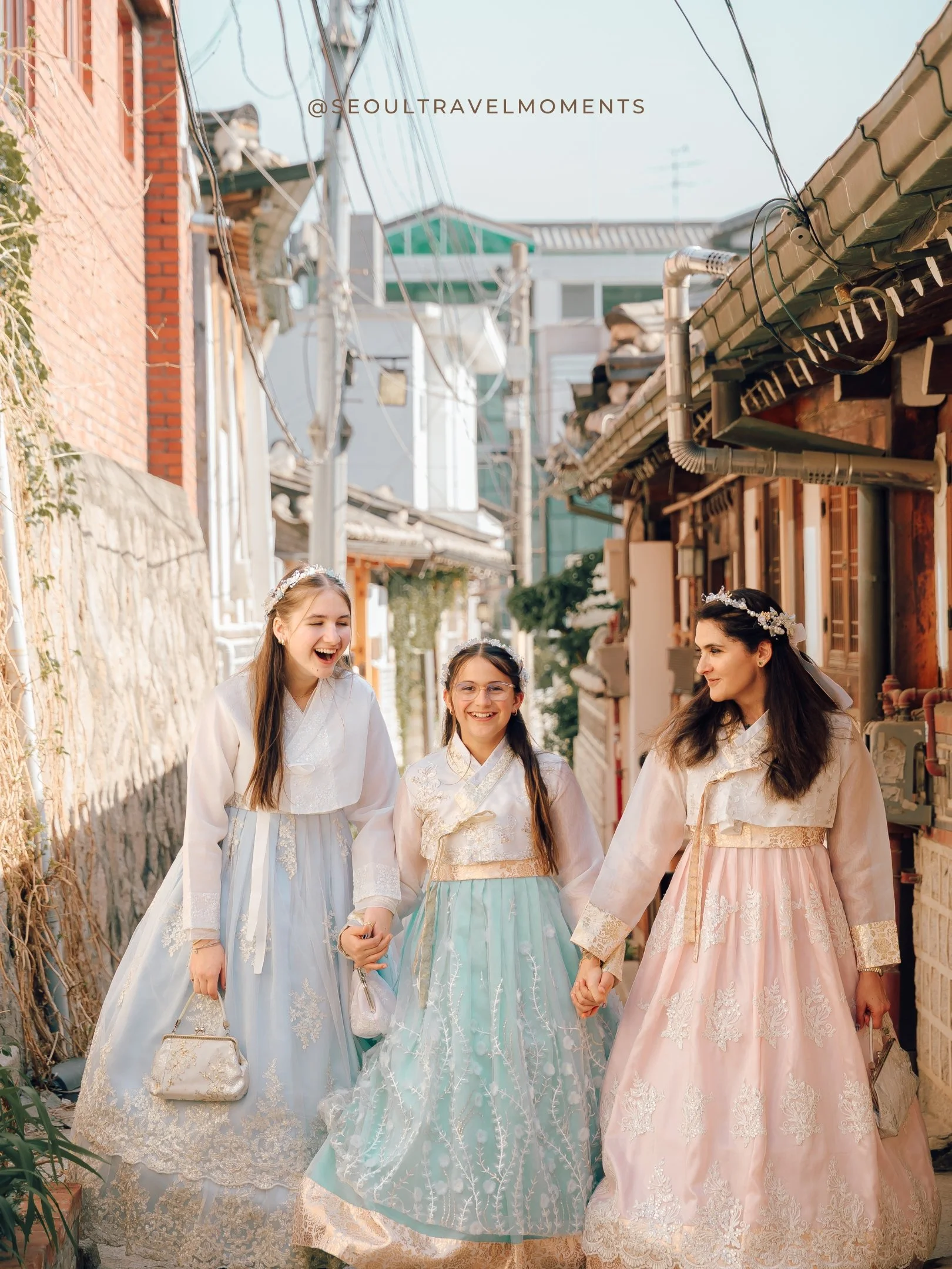 Playful moment between a mom and daughters during a Seoul family photoshoot in hanbok