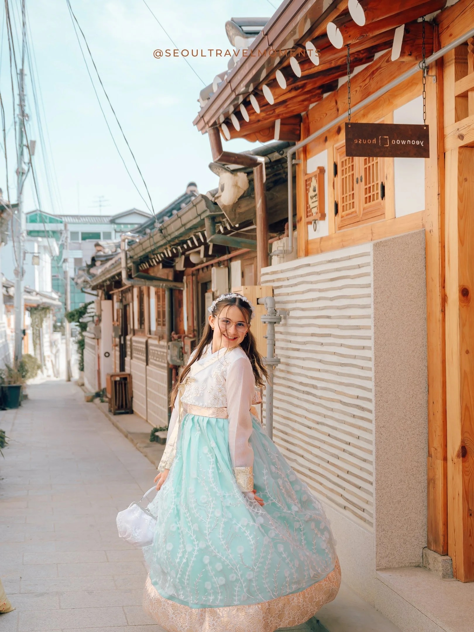 Mother adjusting her daughter’s hanbok during a family photography session in Bukchon
