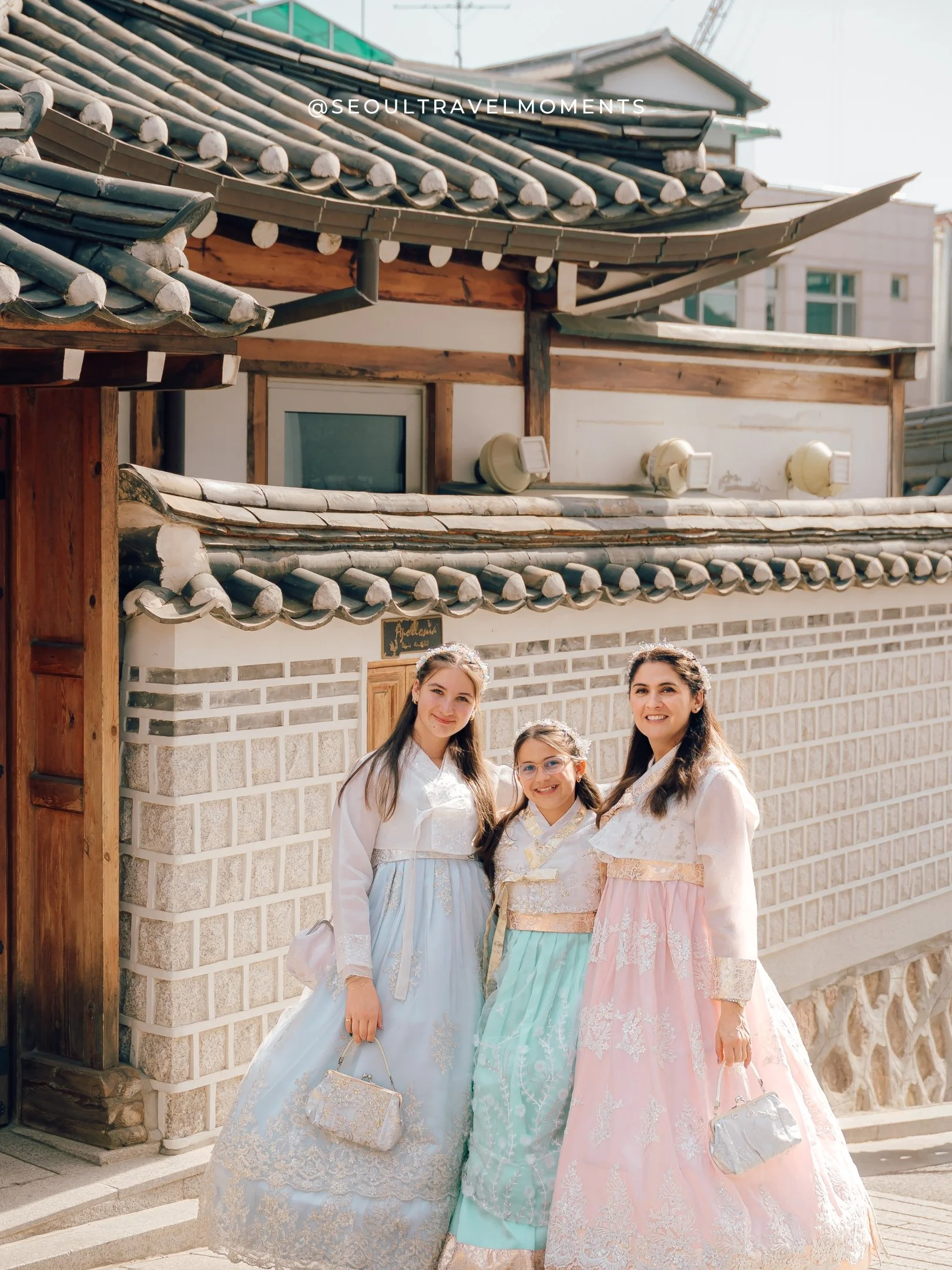 Mother and two daughters walking in Bukchon Hanok Village during a hanbok family photoshoot in Seoul