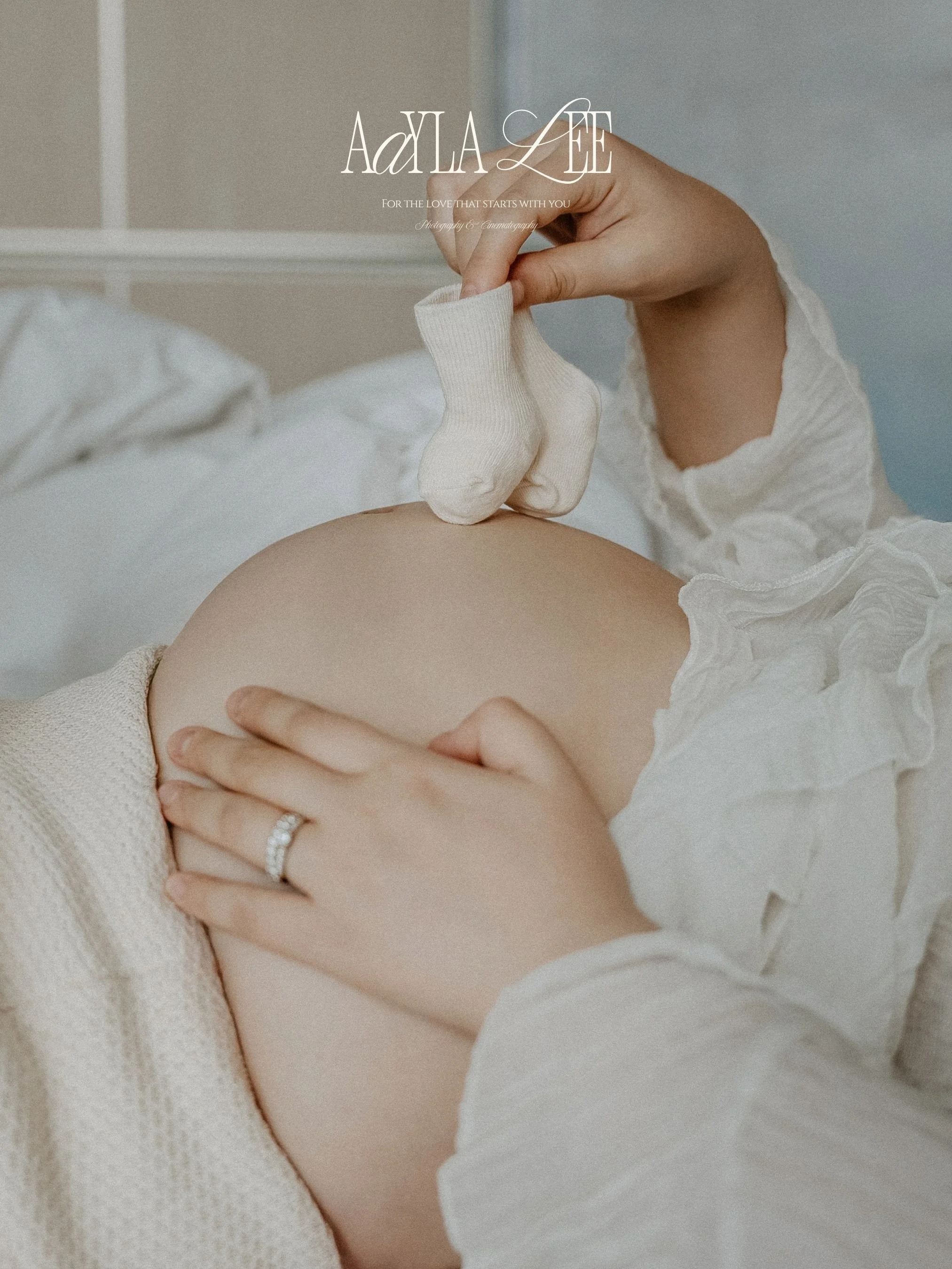 Close-up of hands on pregnant belly, natural light hotel suite, Fairmont Seoul