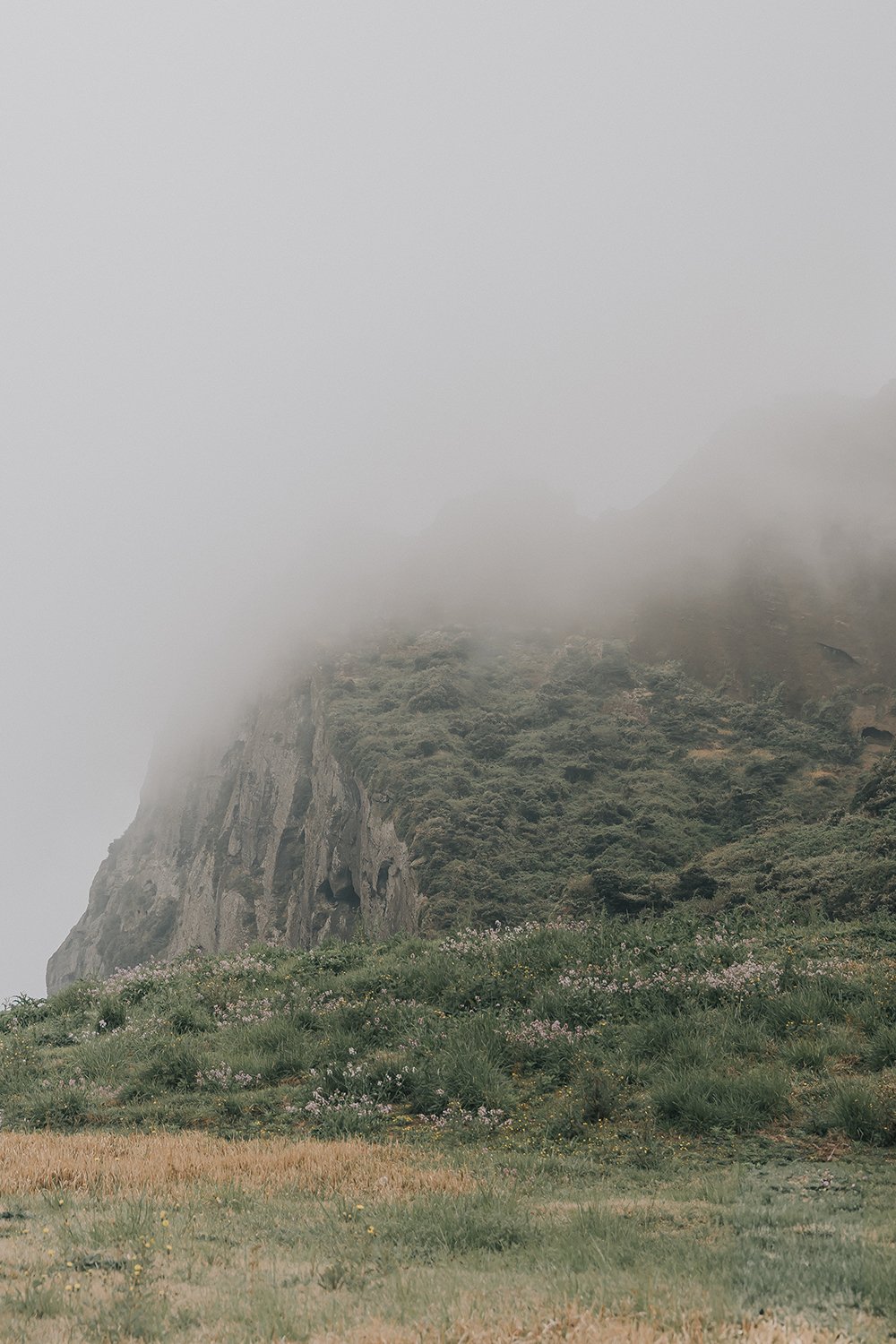 Cinematic view from Seongsan Ilchulbong looking out over the East China Sea on a misty spring day in Jeju Island South Korea