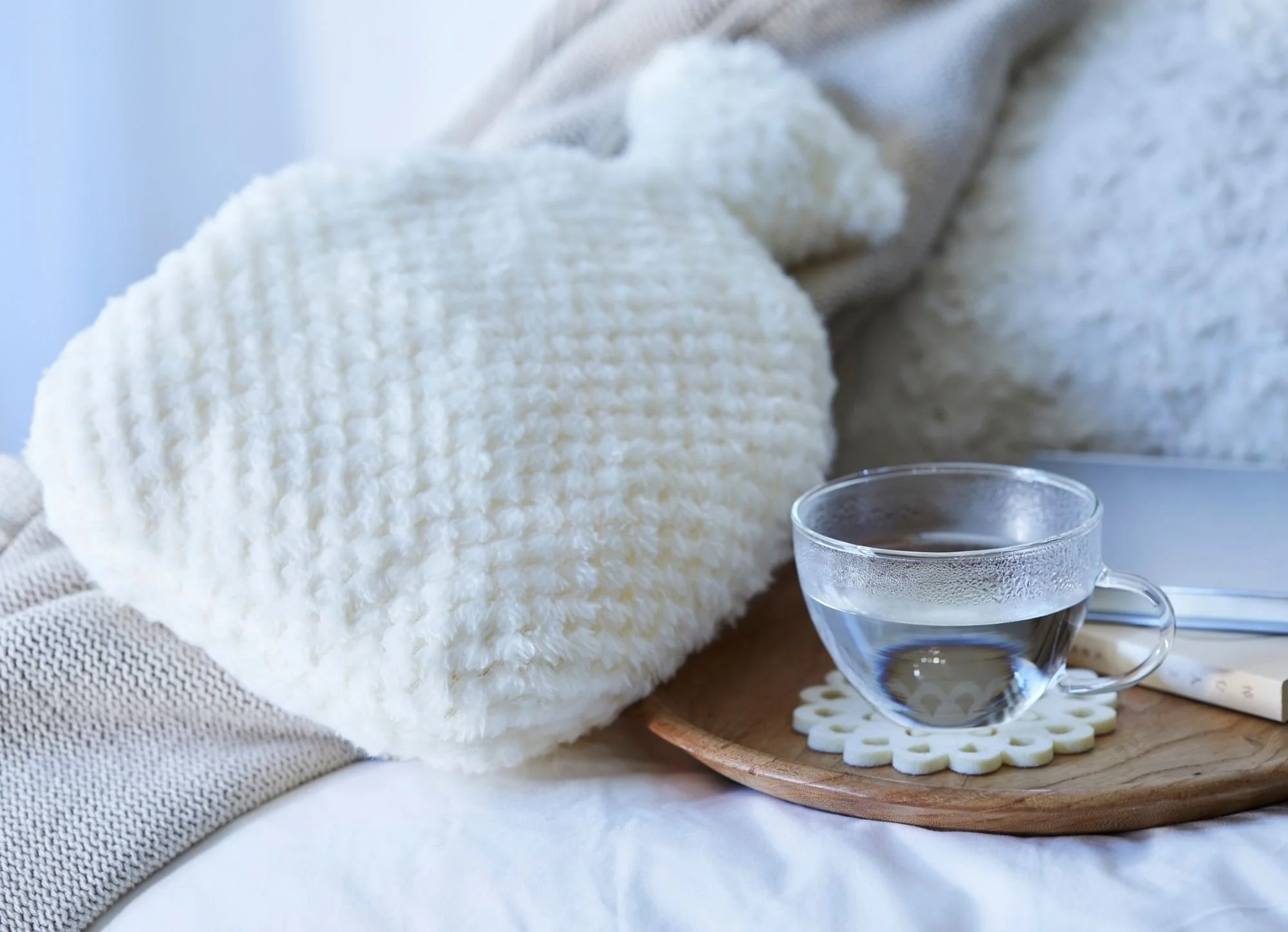 Bouillotte chaude et infusion de plantes posées sur une table, illustration des solutions naturelles pour soulager les règles douloureuses chez l’adolescente à Saint Georges du Bois