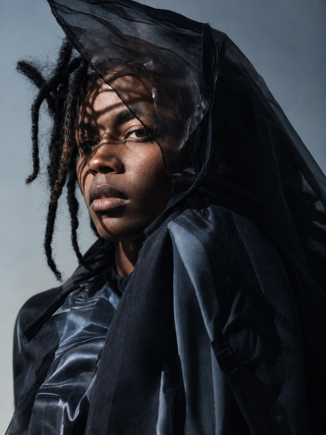 Close-up fashion portrait of a model draped in sculptural black fabric in the Velvet project by Krys Kona