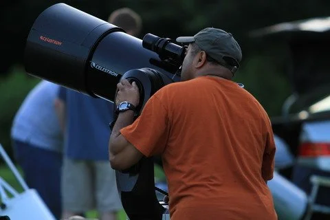 Person using a large telescope outdoors