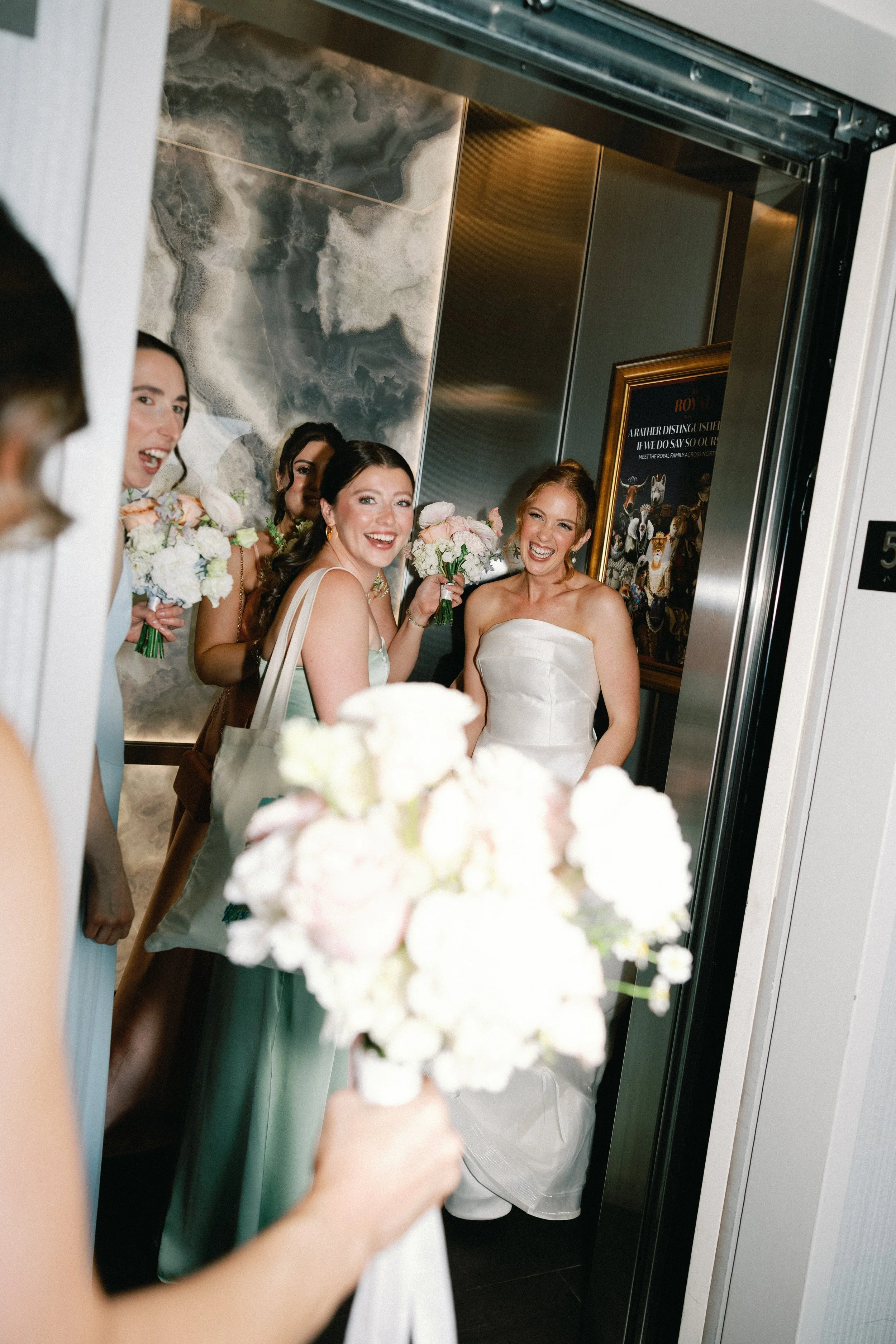 bride and bridesmaids in elevator with border
