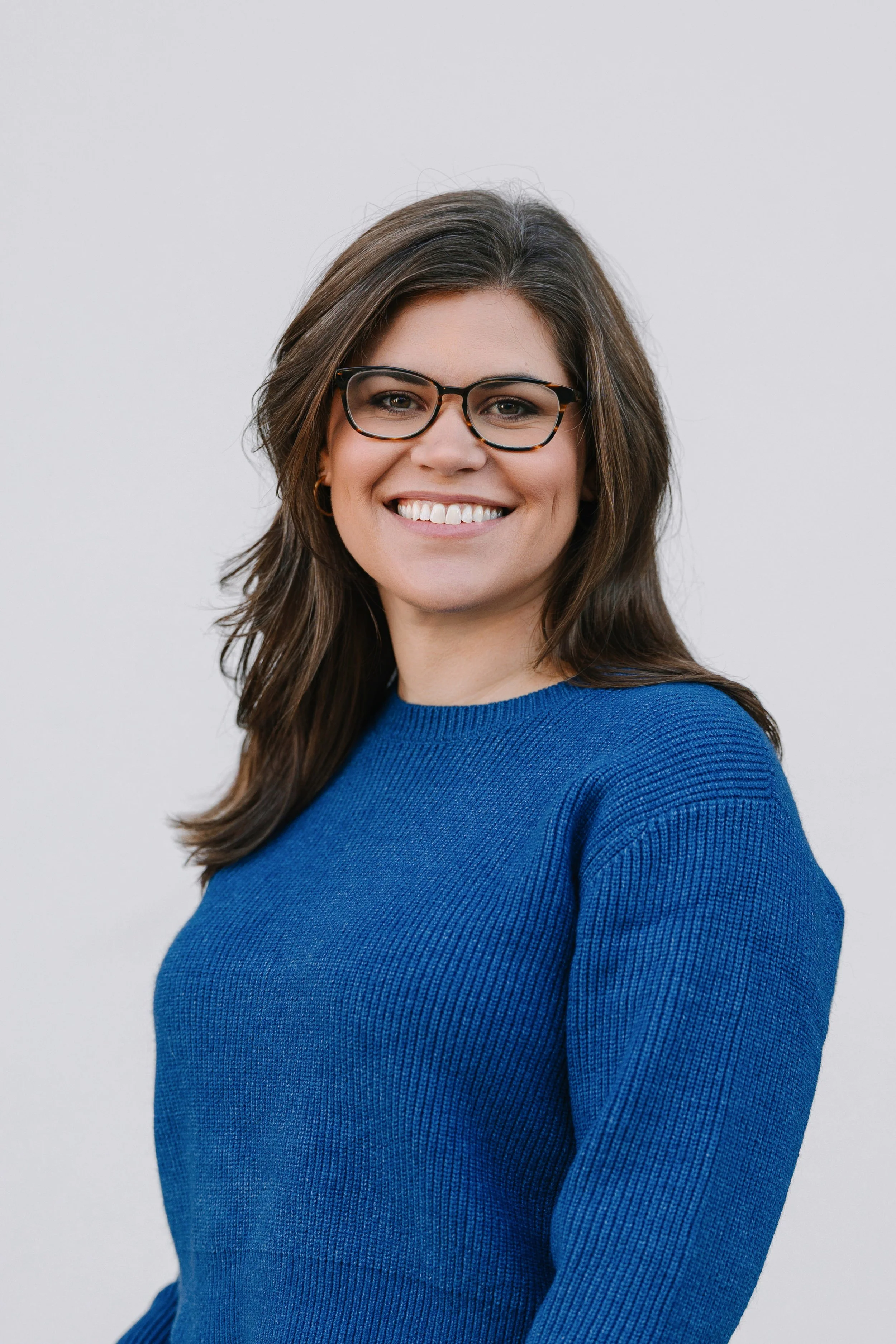 Headshot of Tessa Alves Fortes, smiling at the camera against a clean neutral background