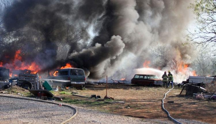 Fire personnel working to extinguish a large multivehicle/brush fire.