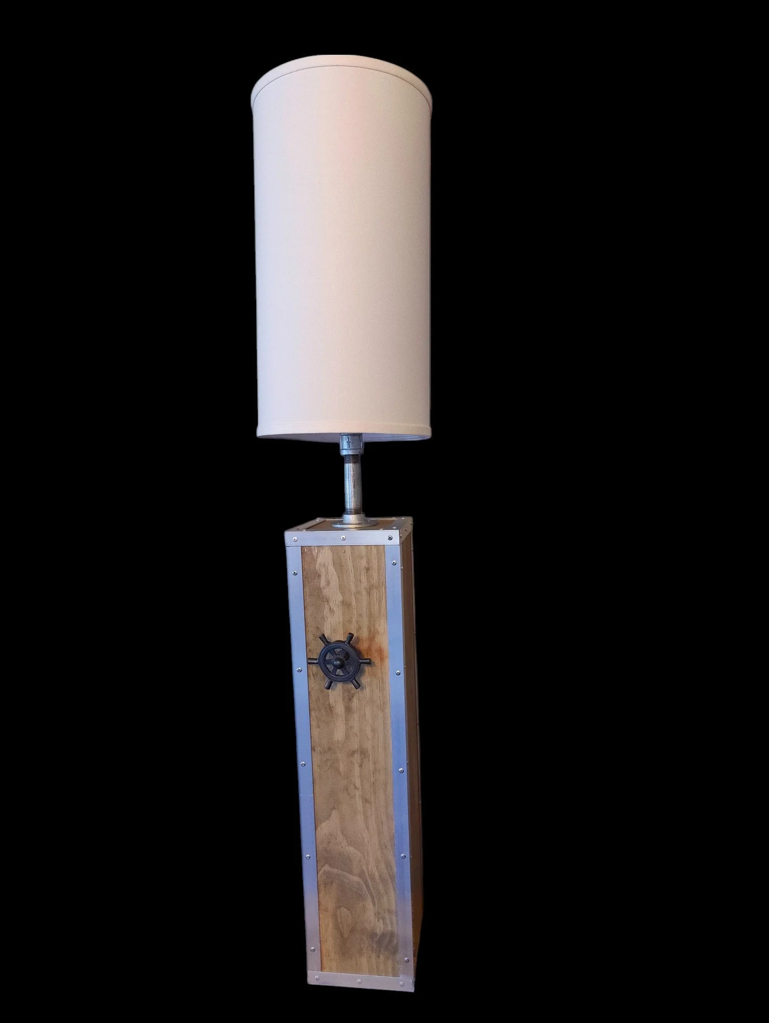 A tall floor lamp with a wooden rectangular base, metal accents, and a white cylindrical lampshade.