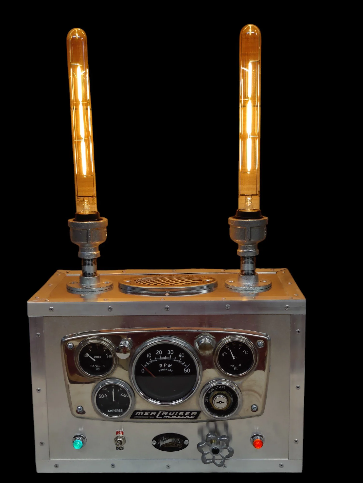 Vintage Mercruiser marine dash with gauges, switches, and knobs on a metal panel against a black background.