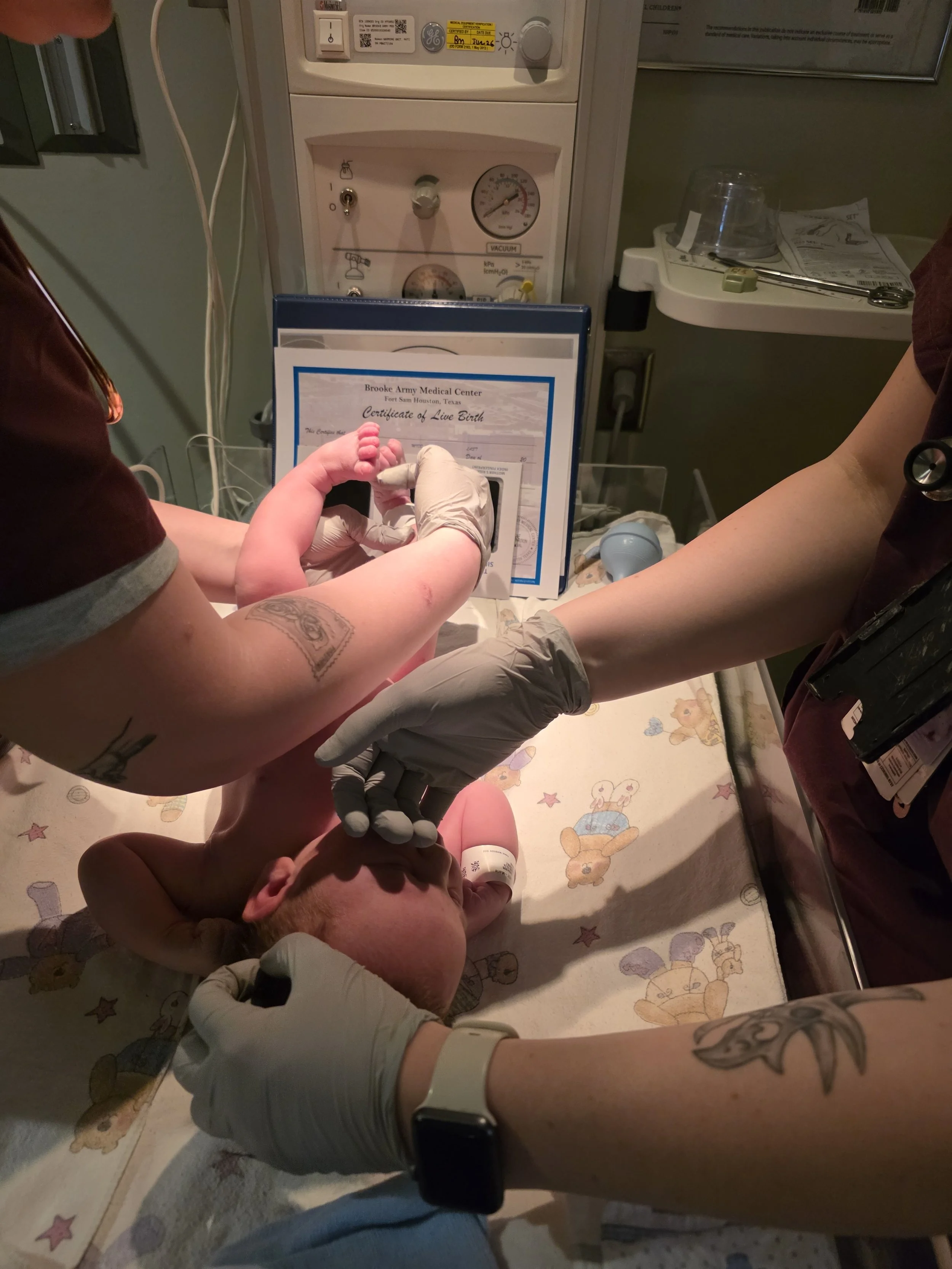 Baby born at a hospital unmedicated in San Antonio with a doula getting feet prints on certificate