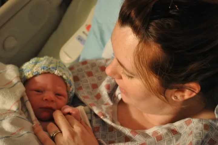 1st time mom looks at her new born baby after having a natural birth in a San Antonio hospital.