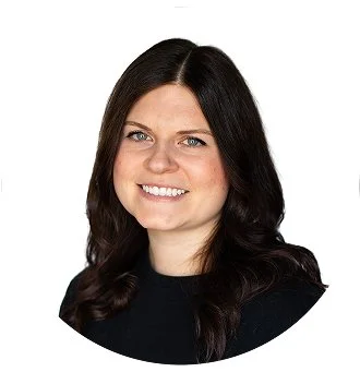 Headshot of a woman with long, dark hair and blue eyes, smiling, wearing a black top.