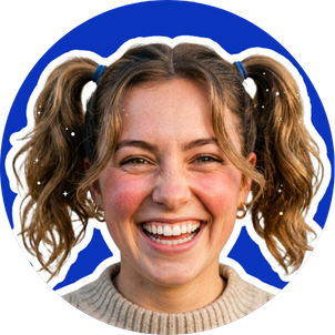 Young girl smiling with pigtails and a gray sweater