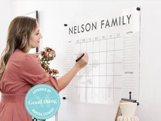WOMAN WRITING ON ACRYLIC CALENDER
