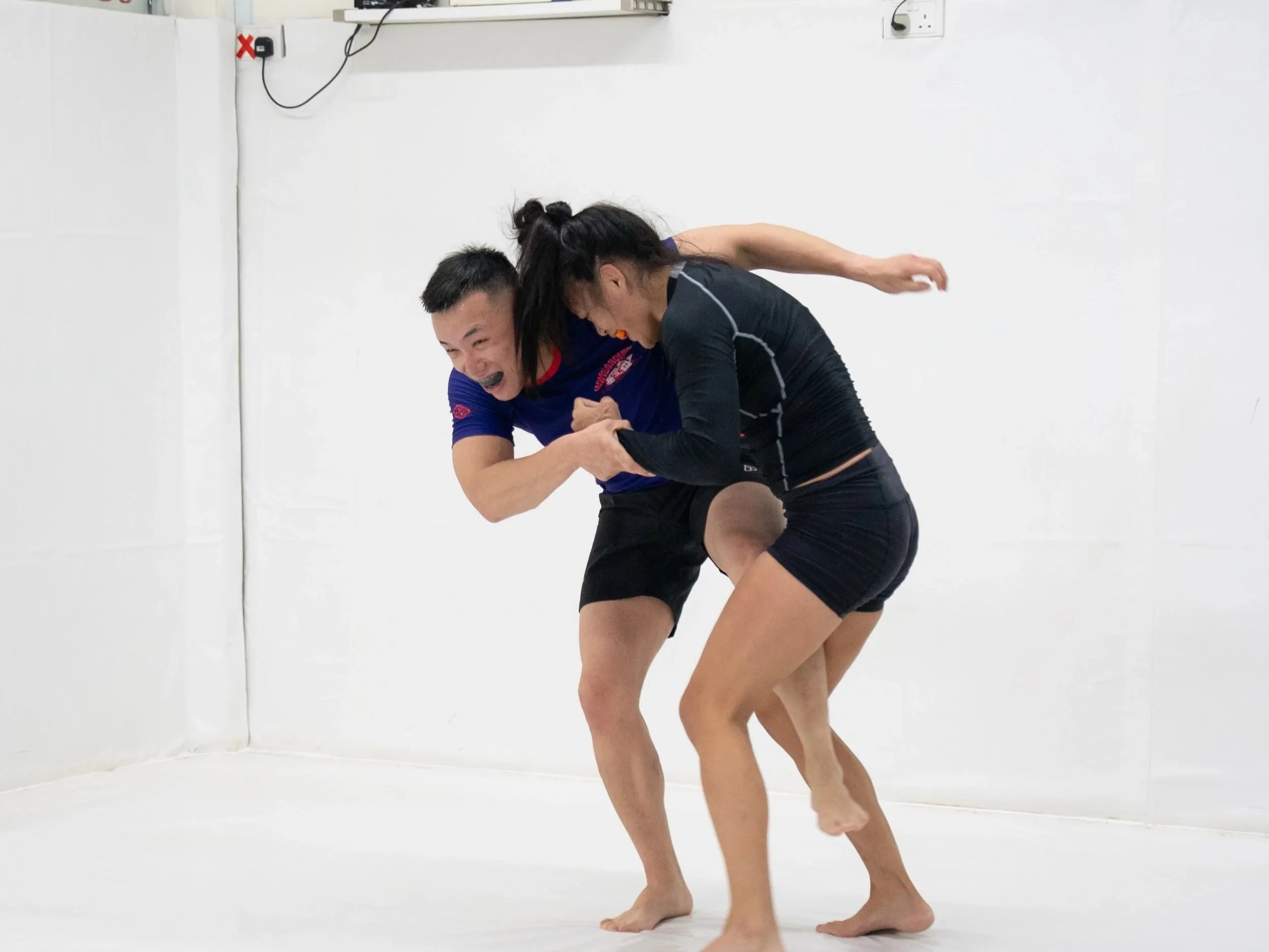 A pair showcasing strength and focus during a wrestling drill, highlighting the high-level athletic training