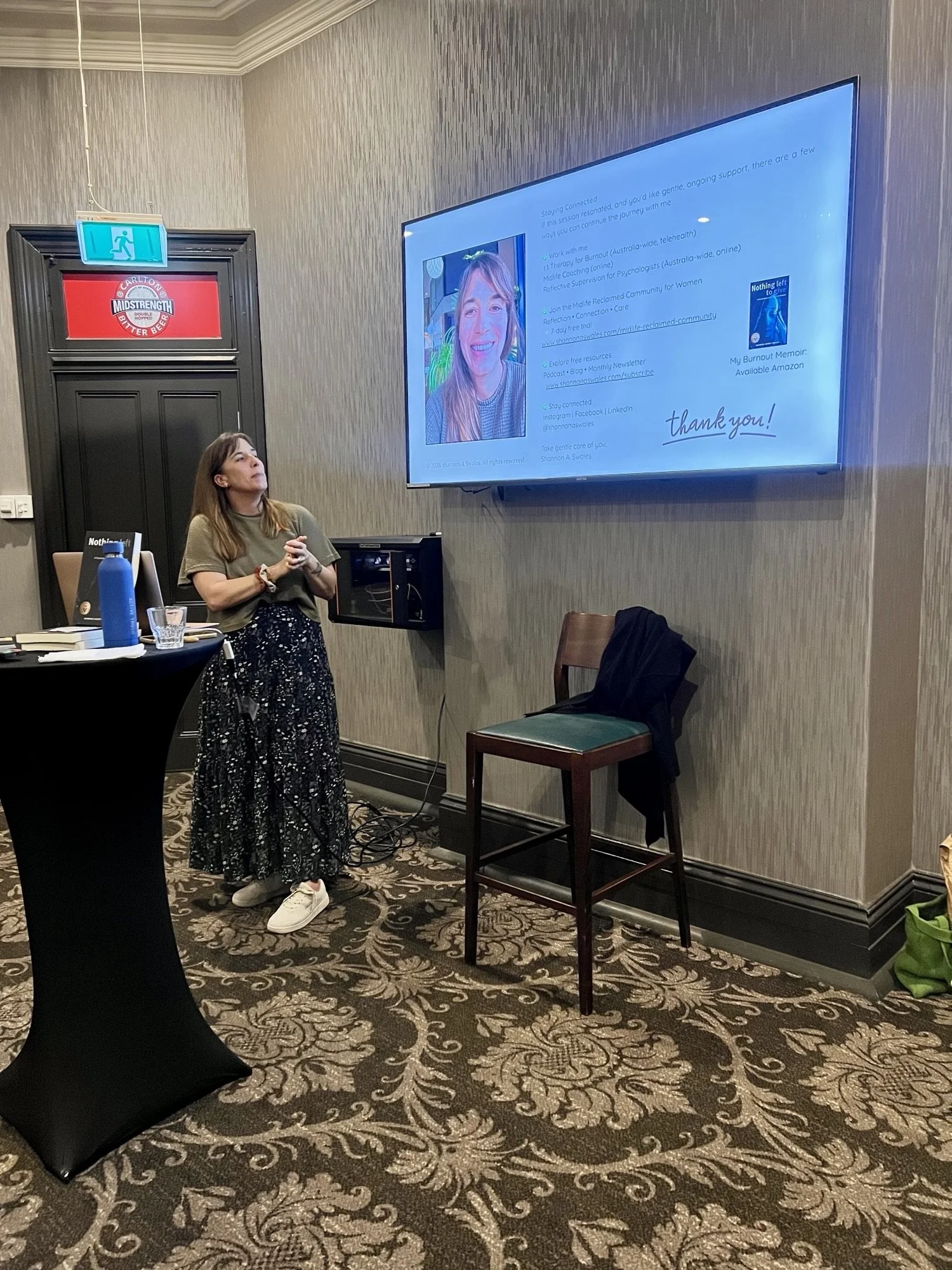 Speaker, Shannon Looking up to screen speaking on burnout