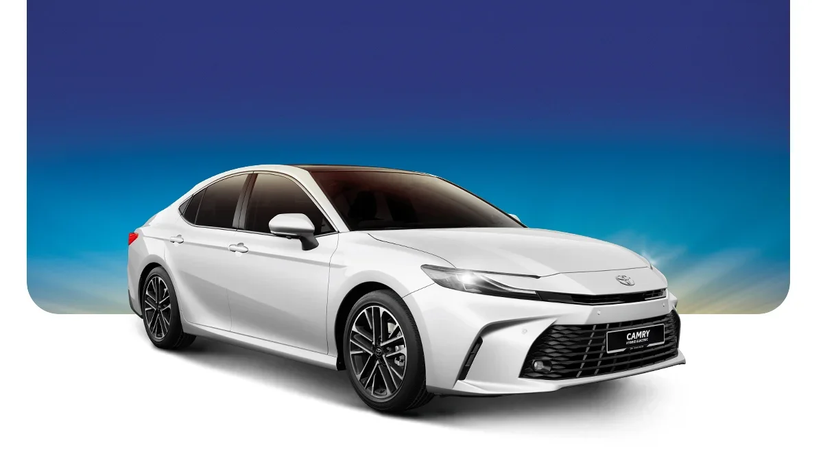 White Toyota Camry sedan car with black windows and black wheels against a blue sky background.