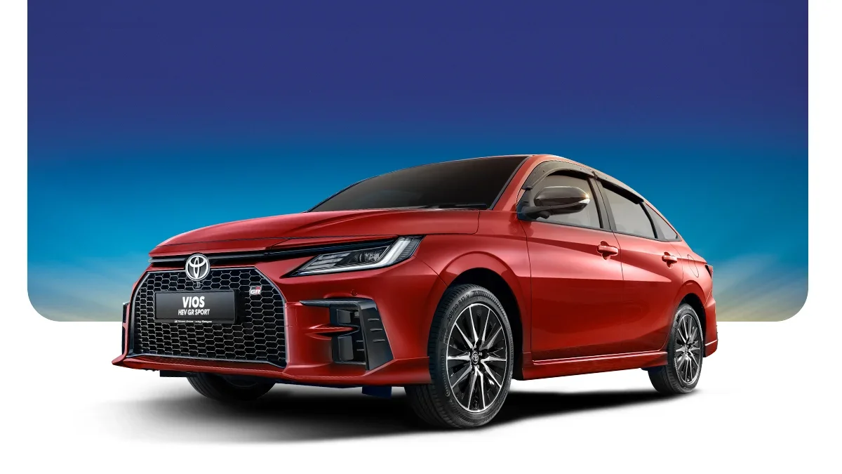 Red Toyota Vios NEV GR Sport sedan against a gradient blue sky background