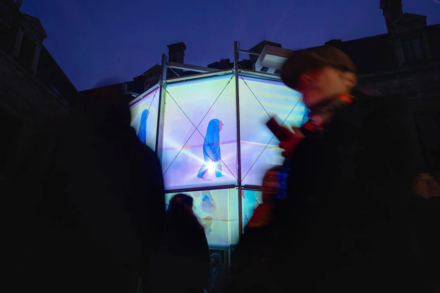 Visitors walking around Morphosis public art installation in an outdoor festival context.