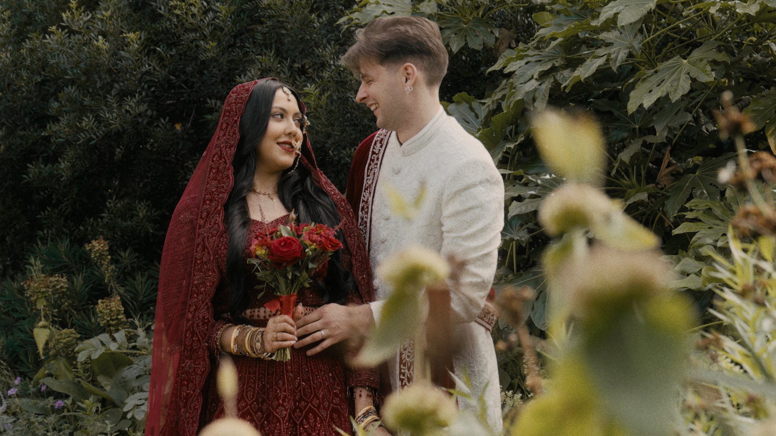 bride and groom looking at each other in a garden