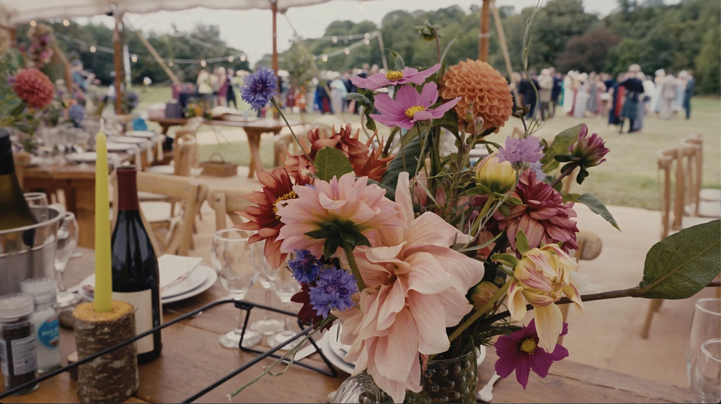 Wedding table covered with flowers and guests in the background