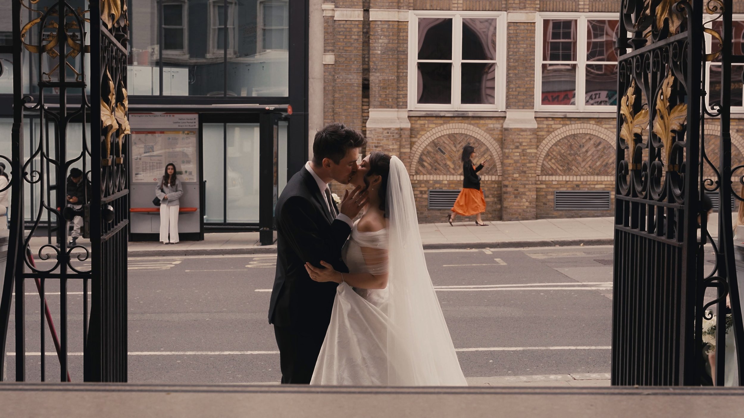 Bride and groom kissing on the street
