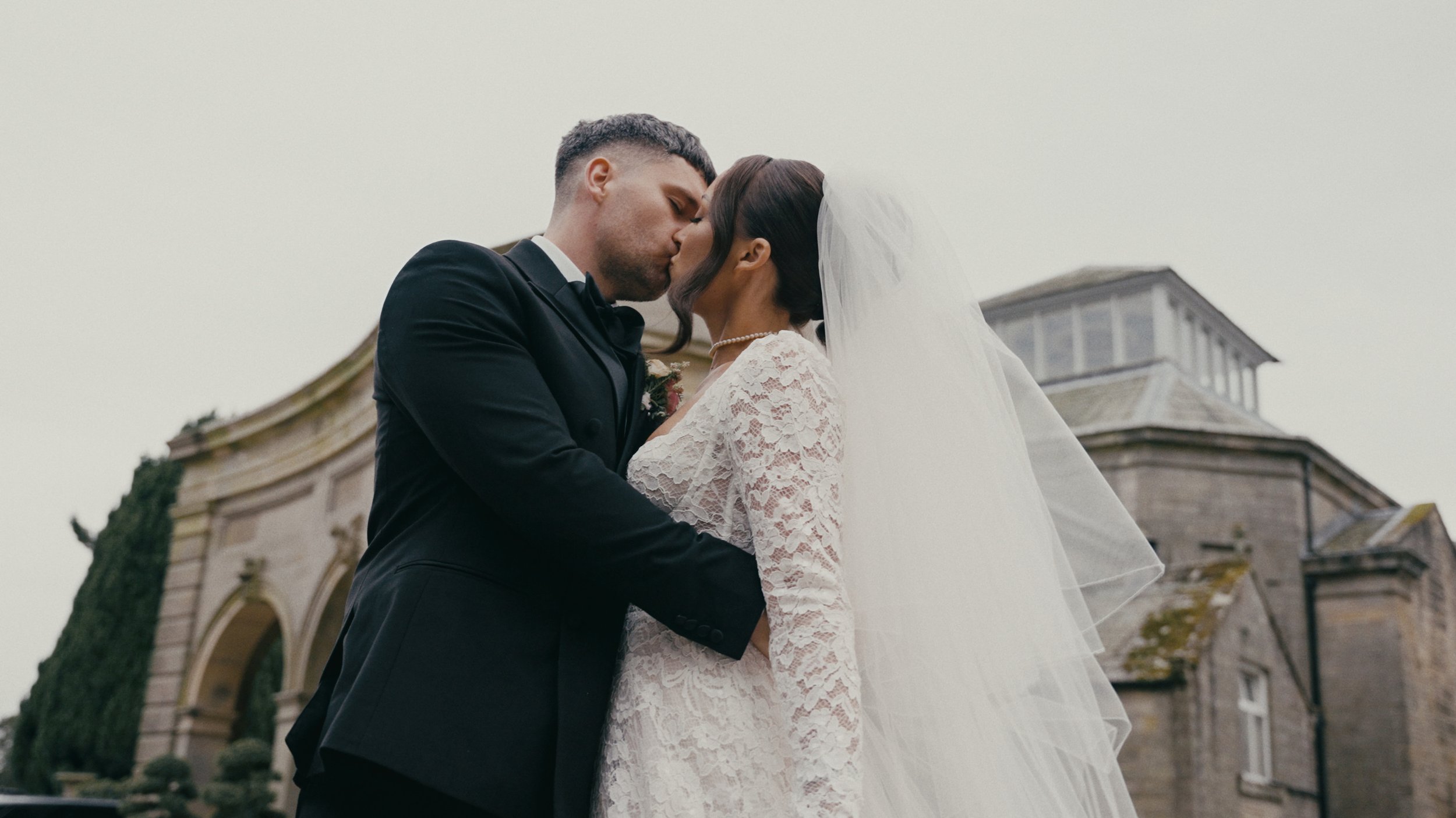 bride and groom kissing outside of Lartington Hall