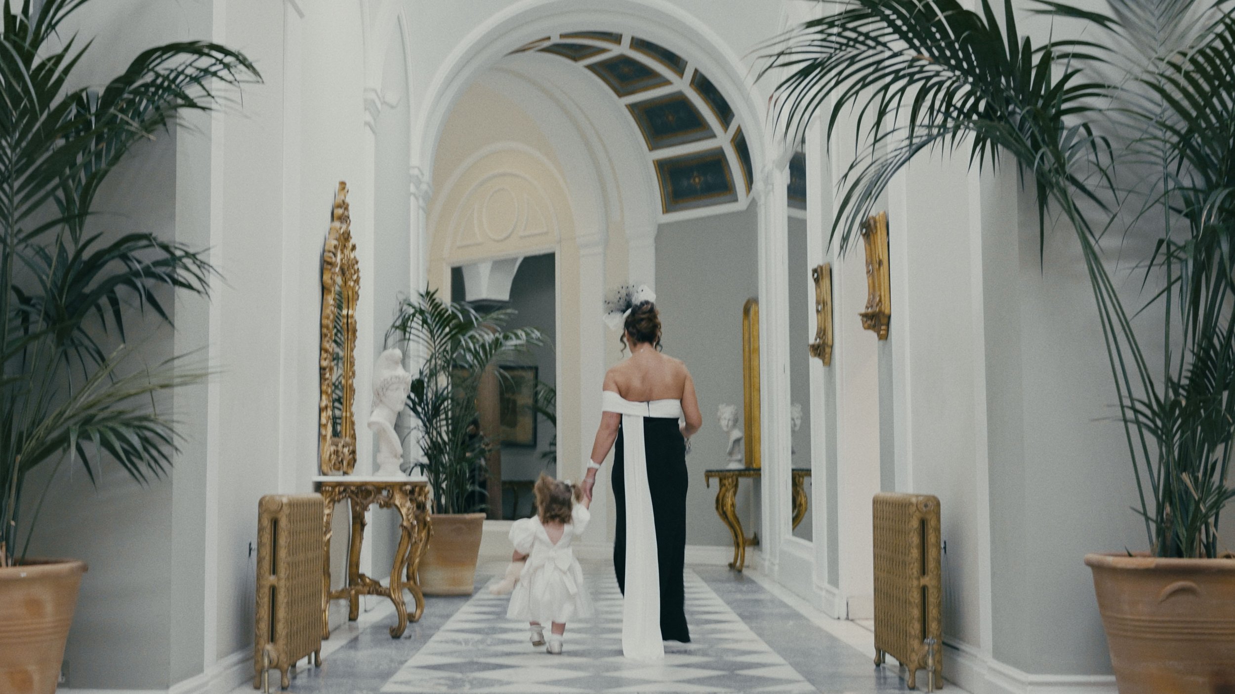 toddler and grandma walking down the corridor of Lartington Hall