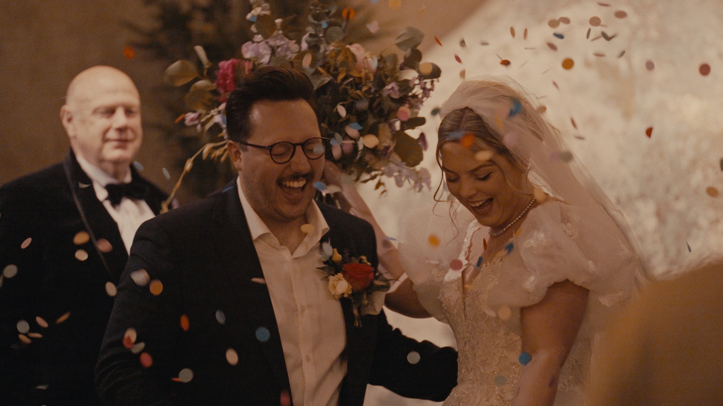 Bride and groom laughing in confetti