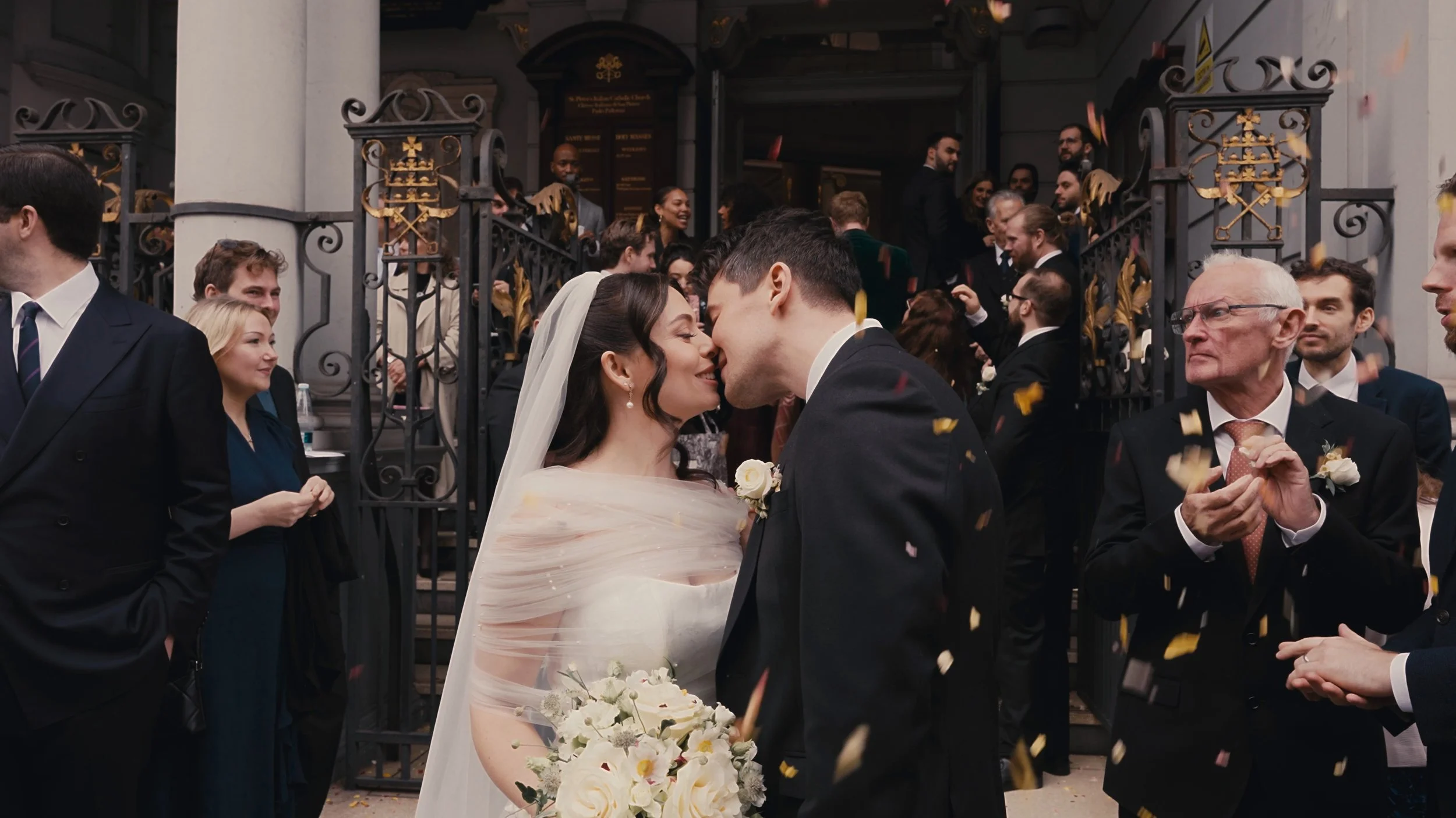 Bride and groom kissing after confetti