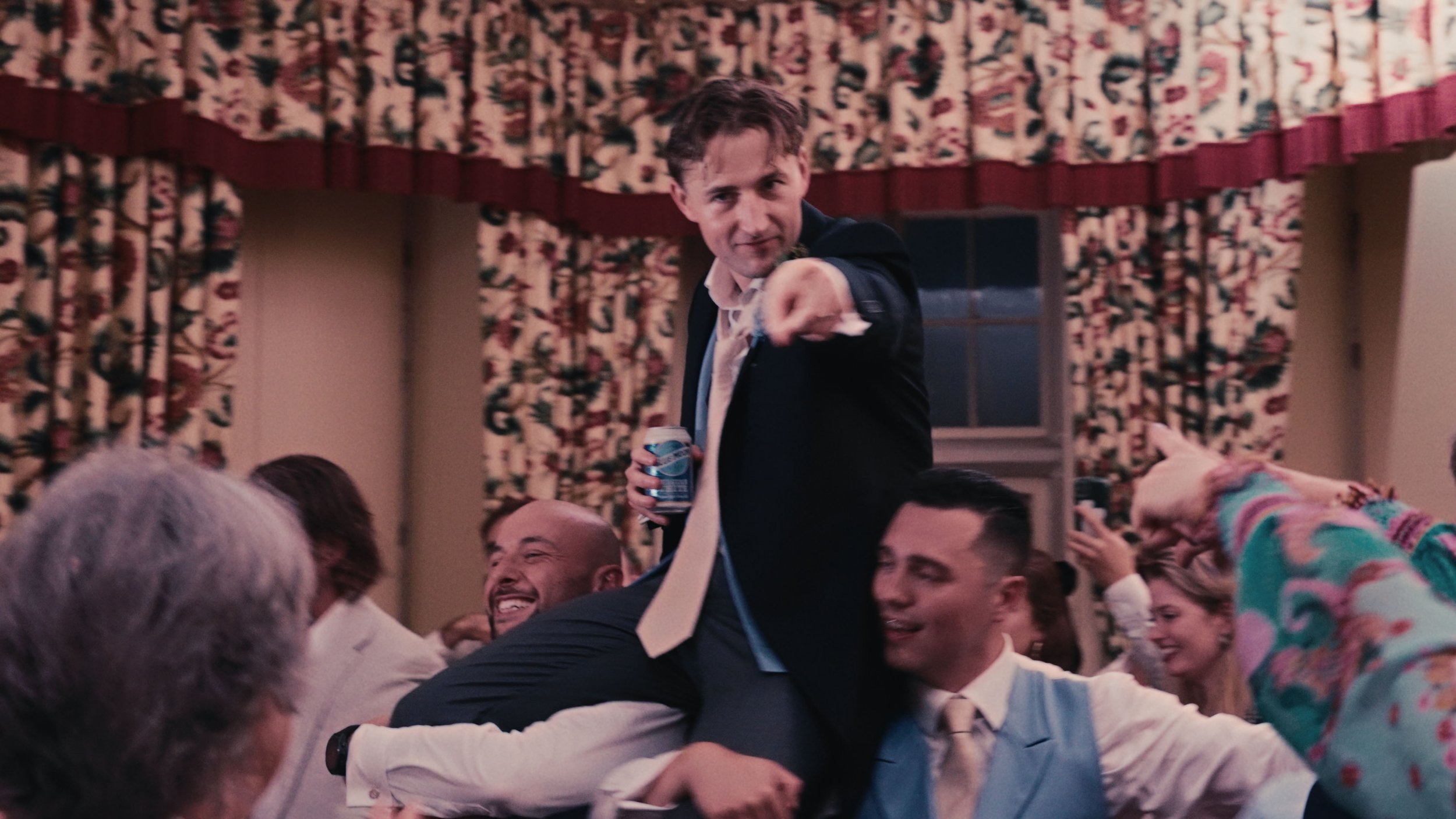 Groom sitting on groomsmen's shoulders.