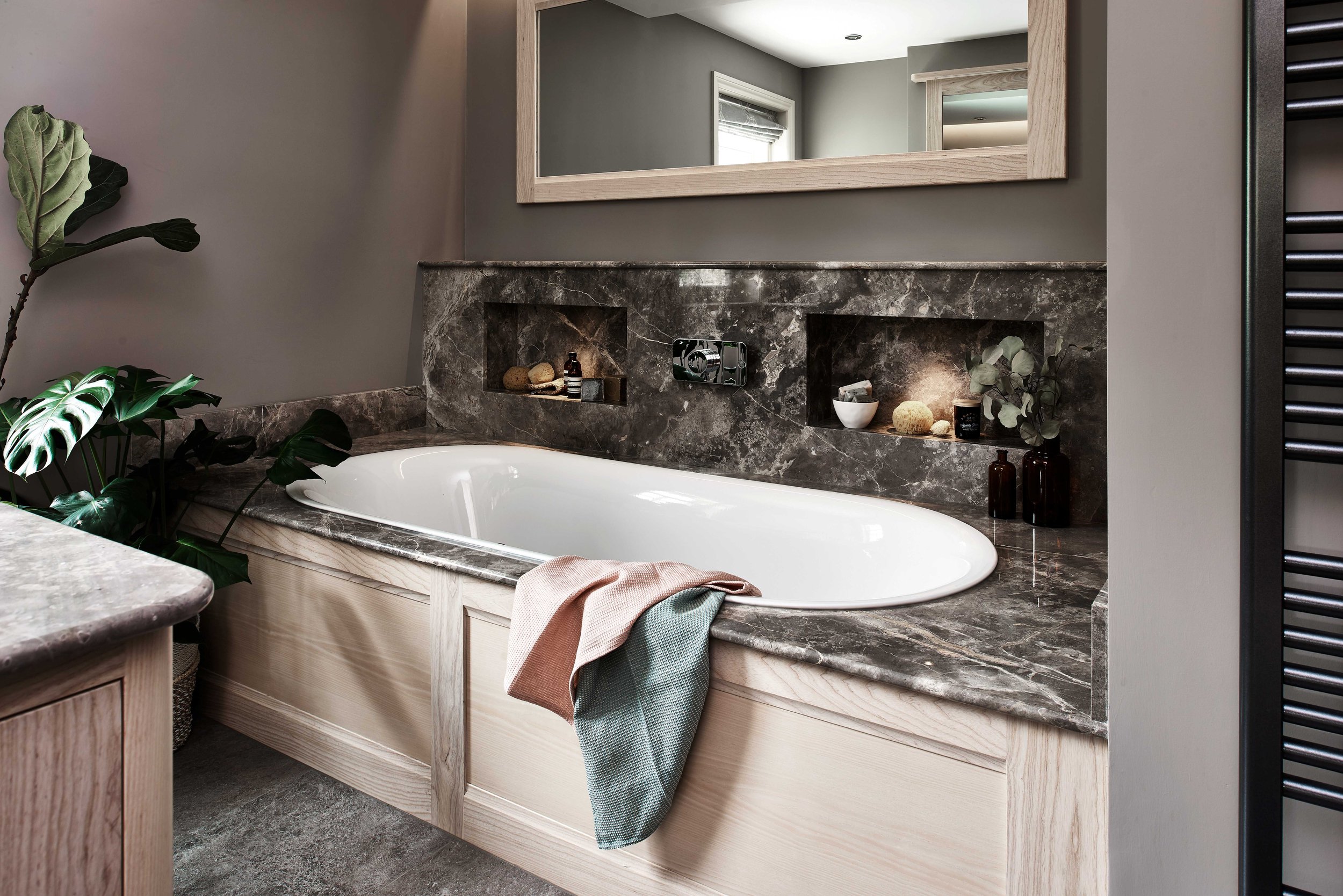 Freestanding designer bath with bespoke handcrafted surround in luxury interior.